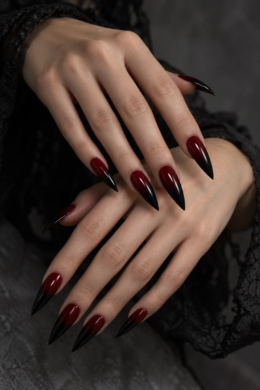 Original black cherry ombré nail inspiration. Long pointed nails blend cherry red into glossy black tips. The gradient is the main detail, with no extra charms.