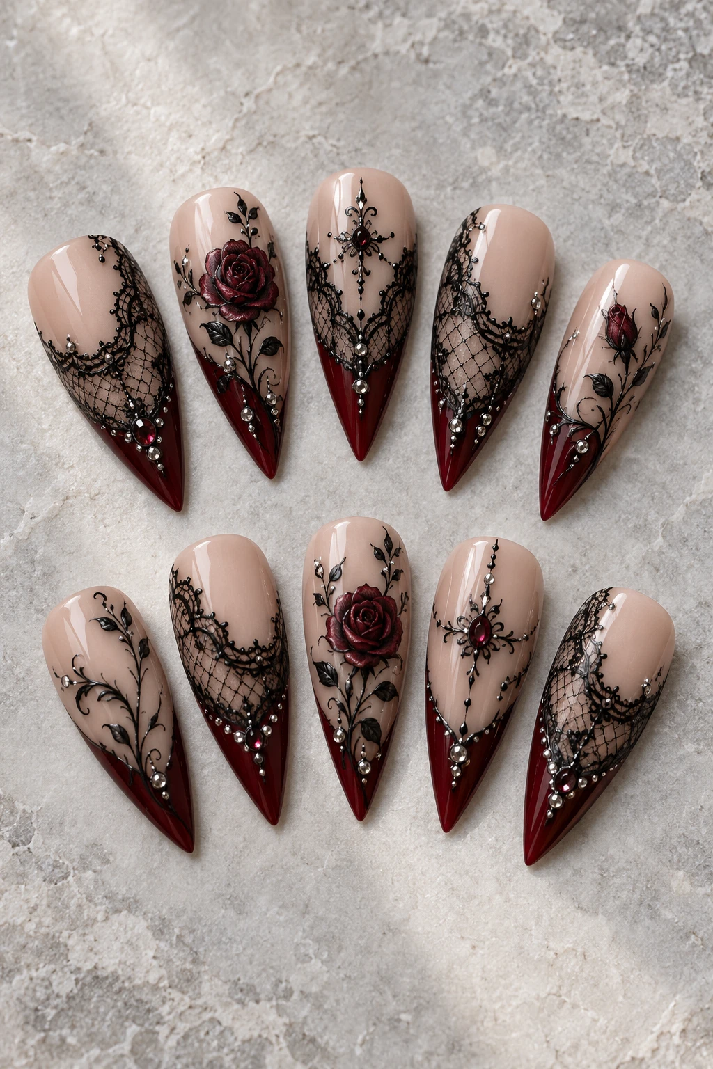 Ten detached long stiletto press-on nail tips: black lace & garnet.